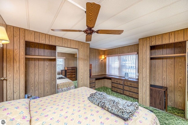 bedroom featuring wood walls, ceiling fan, and carpet