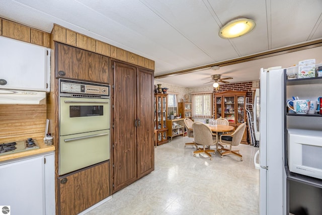 kitchen with white appliances, light countertops, under cabinet range hood, light floors, and ceiling fan
