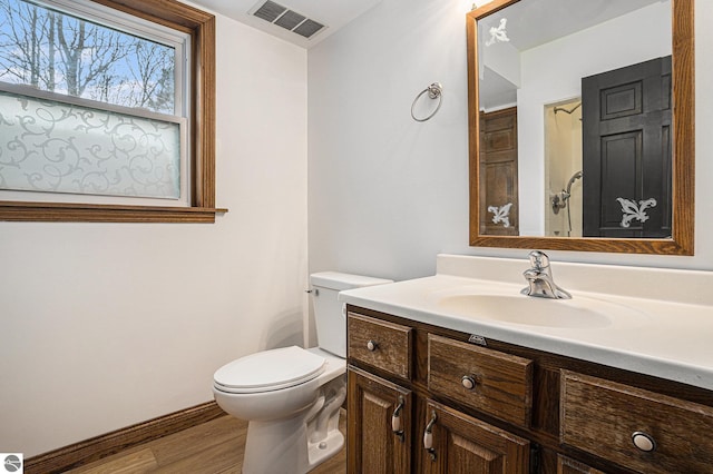 4676 W Mcmillan Rd, Muskegon, MI 49445 - bathroom with toilet, wood finished floors, vanity, and visible vents