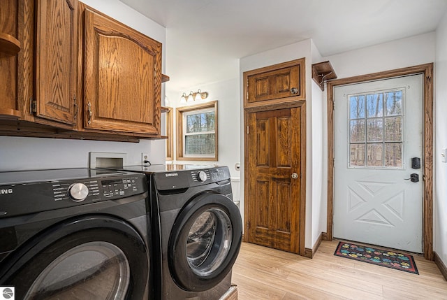 4676 W Mcmillan Rd, Muskegon, MI 49445 - laundry room with light wood-type flooring, washing machine and clothes dryer, cabinet space, and plenty of natural light