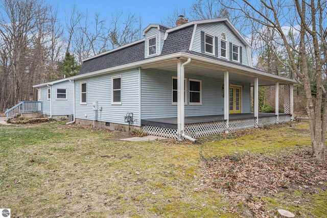 4676 W Mcmillan Rd, Muskegon, MI 49445 - view of home's exterior featuring a yard, a porch, a shingled roof, and a chimney