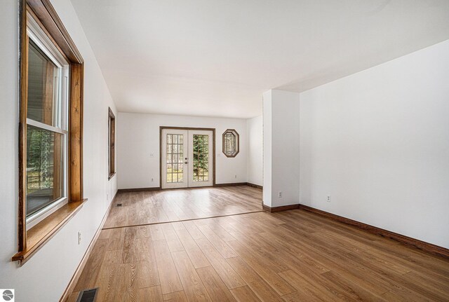 4676 W Mcmillan Rd, Muskegon, MI 49445 - unfurnished room with light wood finished floors, french doors, baseboards, and visible vents