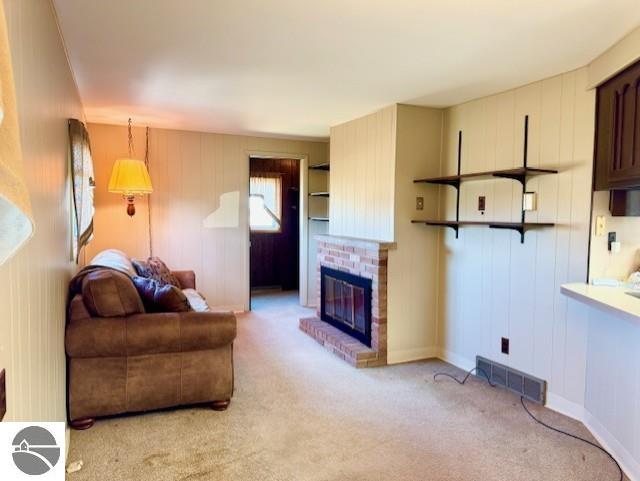 1705 S State Rd, Ithaca, MI 48847 - living room featuring light carpet, visible vents, and a brick fireplace