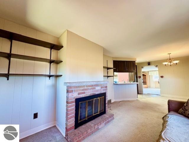 1705 S State Rd, Ithaca, MI 48847 - living room featuring a notable chandelier, light carpet, and a fireplace