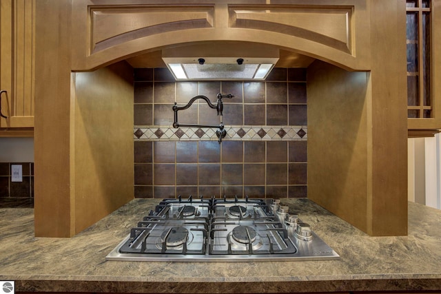 kitchen with arched walkways and stainless steel gas cooktop