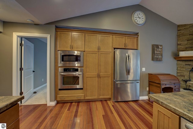 kitchen with dark wood-type flooring, baseboards, vaulted ceiling, and appliances with stainless steel finishes