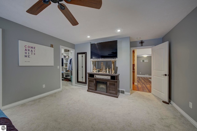 unfurnished living room featuring carpet flooring, visible vents, baseboards, and ceiling fan