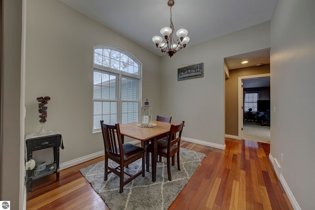dining room with hardwood / wood-style floors, a notable chandelier, and baseboards