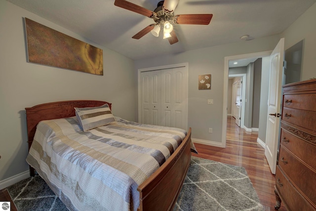 bedroom featuring a closet, baseboards, ceiling fan, and wood finished floors