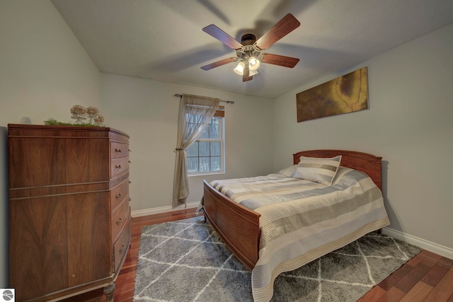bedroom with dark wood-type flooring, baseboards, and a ceiling fan