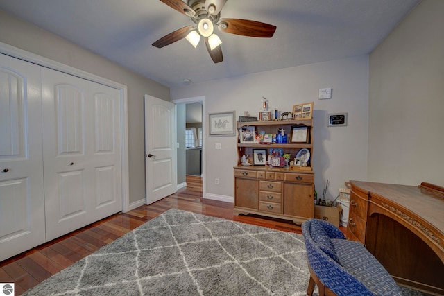 bedroom featuring wood finished floors, a closet, a ceiling fan, and baseboards