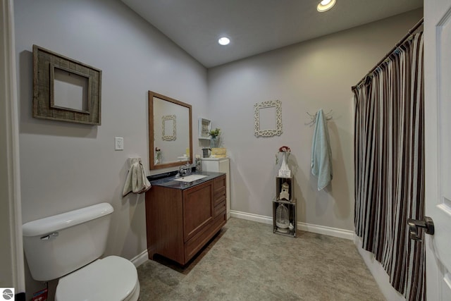 bathroom featuring toilet, vanity, baseboards, and recessed lighting