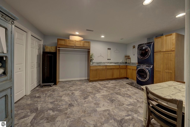 kitchen with brown cabinets, recessed lighting, light countertops, and stacked washer / drying machine