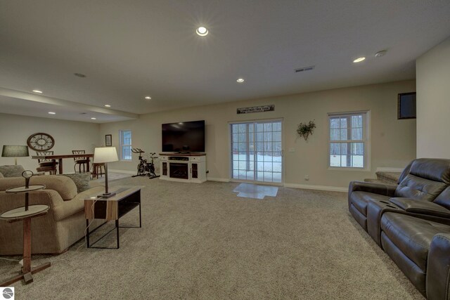 carpeted living area with a fireplace, recessed lighting, visible vents, and baseboards