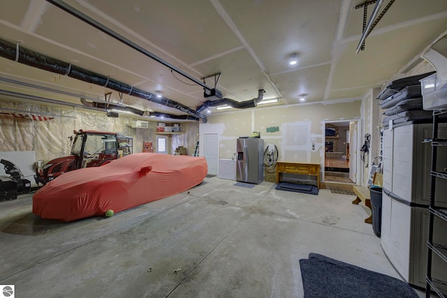 garage featuring stainless steel fridge with ice dispenser and a garage door opener