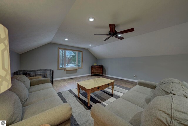 living room featuring wood finished floors, baseboards, lofted ceiling, and recessed lighting