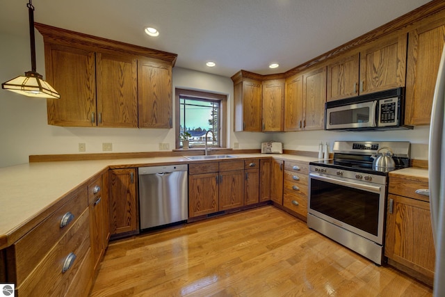 1339 Killdeer Ln, Kingsley, MI 49649 - kitchen featuring brown cabinetry, light wood-type flooring, appliances with stainless steel finishes, a sink, and light countertops
