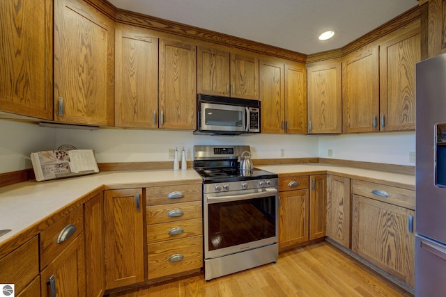 1339 Killdeer Ln, Kingsley, MI 49649 - kitchen with brown cabinets, light wood-type flooring, light countertops, and appliances with stainless steel finishes