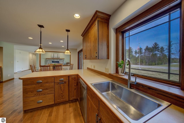 1339 Killdeer Ln, Kingsley, MI 49649 - kitchen with a sink, open floor plan, a peninsula, brown cabinetry, and stainless steel dishwasher