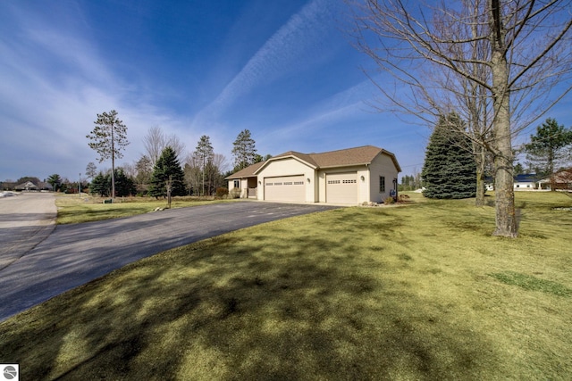 1339 Killdeer Ln, Kingsley, MI 49649 - view of front of property featuring a garage, a front yard, and aphalt driveway
