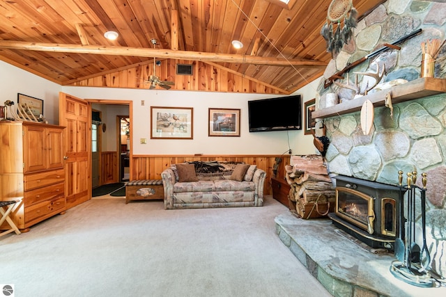 living room featuring wood ceiling, a wood stove, a wainscoted wall, and carpet floors