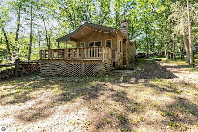 rear view of property featuring a wooden deck and a chimney