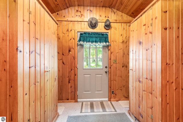 doorway to outside featuring wood walls, wooden ceiling, and lofted ceiling