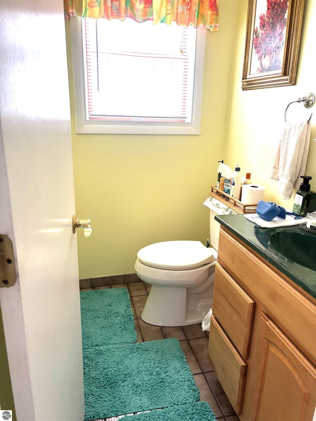 7119 Lakewood Dr, Oscoda, MI 48750 - half bath with toilet, tile patterned floors, vanity, and plenty of natural light