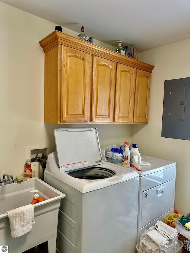 7119 Lakewood Dr, Oscoda, MI 48750 - washroom with cabinet space, washing machine and clothes dryer, electric panel, and a sink