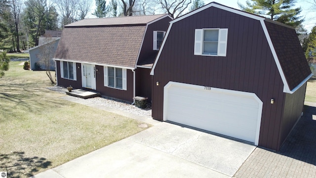 7119 Lakewood Dr, Oscoda, MI 48750 - colonial inspired home with a gambrel roof, roof with shingles, a front yard, a garage, and concrete driveway