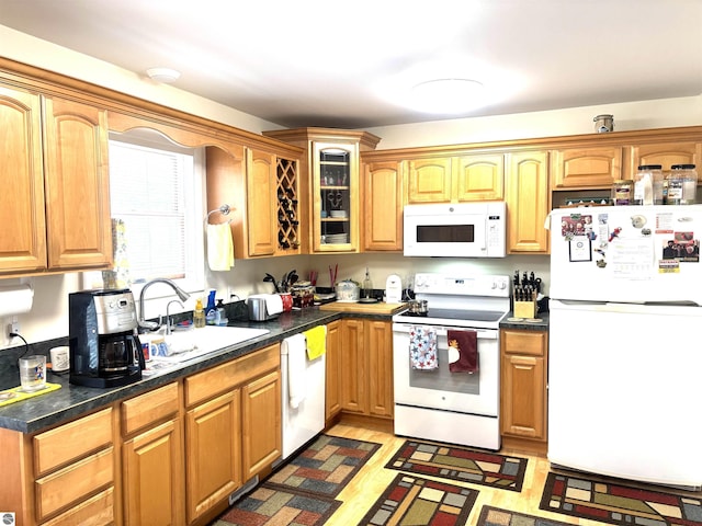 7119 Lakewood Dr, Oscoda, MI 48750 - kitchen featuring light wood-type flooring, white appliances, glass insert cabinets, dark countertops, and a sink