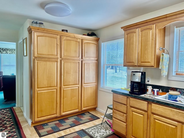 7119 Lakewood Dr, Oscoda, MI 48750 - kitchen featuring baseboards, dark countertops, light brown cabinetry, and light wood finished floors
