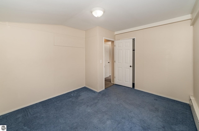 316 Grafton Ave, Alma, MI 48801 - spare room featuring a baseboard heating unit, dark colored carpet, and vaulted ceiling