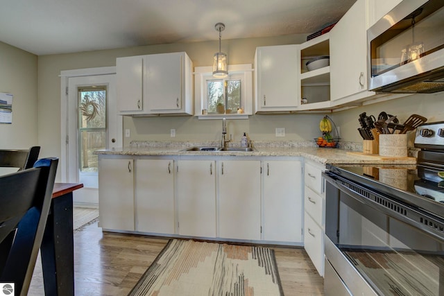kitchen with stainless steel microwave, plenty of natural light, electric range, and a sink