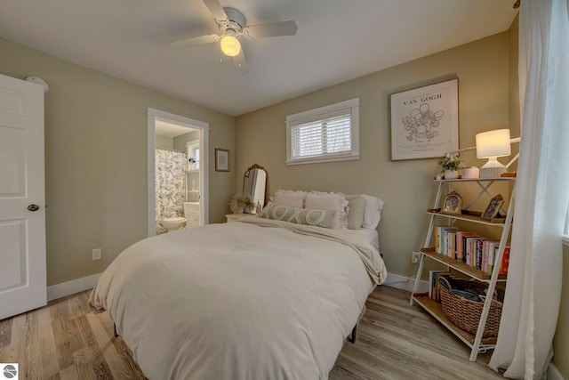 bedroom featuring light wood-type flooring, ensuite bathroom, baseboards, and ceiling fan