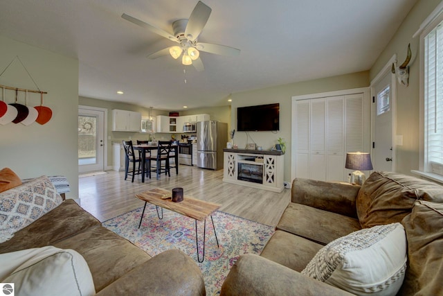 living room with recessed lighting, a ceiling fan, and light wood-type flooring