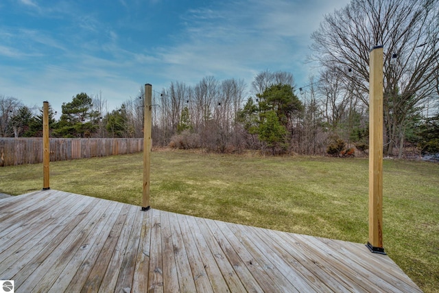 deck with a lawn and fence