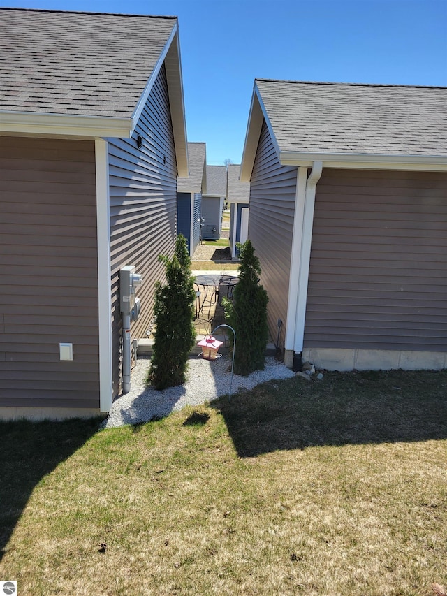 921 Cobalt St Unit 48, Traverse City, MI 49696 - view of property exterior featuring a yard and a shingled roof