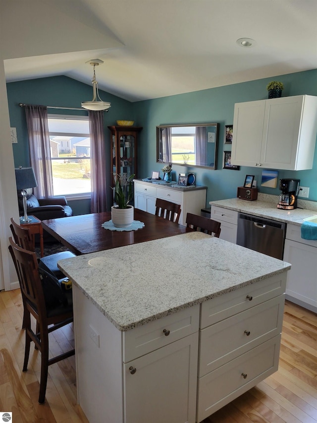 921 Cobalt St Unit 48, Traverse City, MI 49696 - kitchen with stainless steel dishwasher, a center island, light wood finished floors, white cabinets, and lofted ceiling