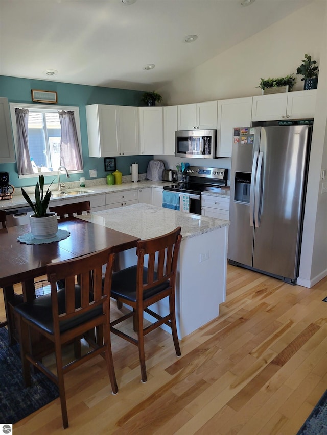 921 Cobalt St Unit 48, Traverse City, MI 49696 - kitchen with stainless steel appliances, light wood finished floors, white cabinets, recessed lighting, and vaulted ceiling
