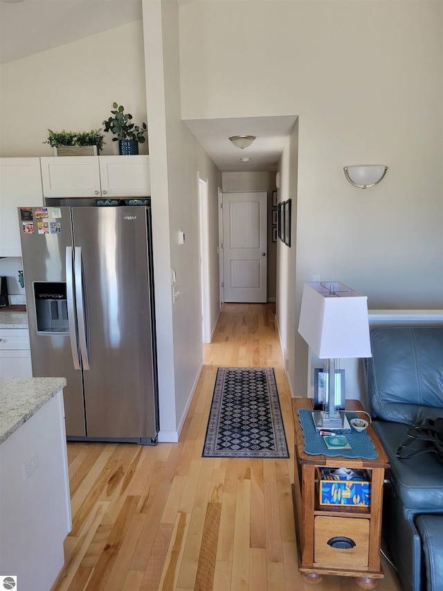 921 Cobalt St Unit 48, Traverse City, MI 49696 - kitchen with stainless steel refrigerator with ice dispenser, light wood finished floors, white cabinets, baseboards, and light stone counters