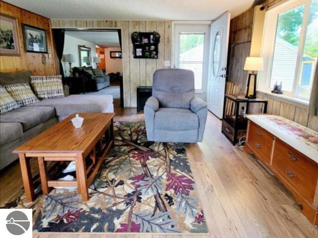 13876 Merrill Ave, Kalkaska, MI 49646 - living room featuring light wood-style flooring and wood walls