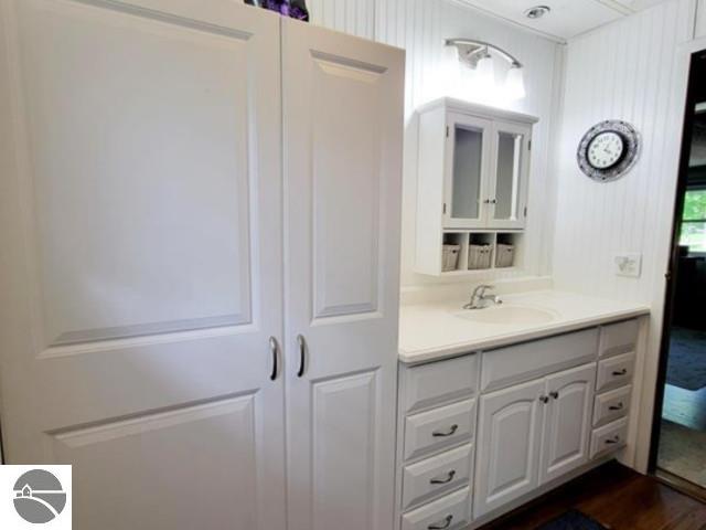 13876 Merrill Ave, Kalkaska, MI 49646 - bathroom with wood finished floors and vanity