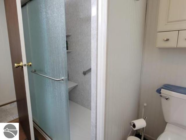 13876 Merrill Ave, Kalkaska, MI 49646 - bathroom featuring a shower stall and toilet