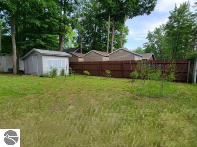 13876 Merrill Ave, Kalkaska, MI 49646 - view of yard with a fenced backyard, an outdoor structure, and a storage unit