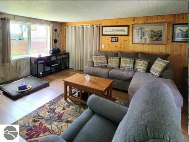 13876 Merrill Ave, Kalkaska, MI 49646 - living room with wooden walls and wood finished floors