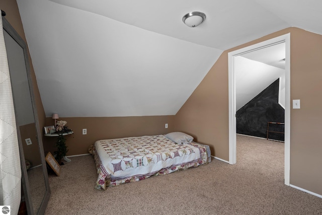 carpeted bedroom featuring vaulted ceiling and baseboards