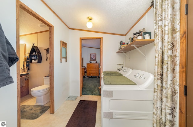 clothes washing area featuring washer and dryer, ornamental molding, a textured ceiling, and laundry area