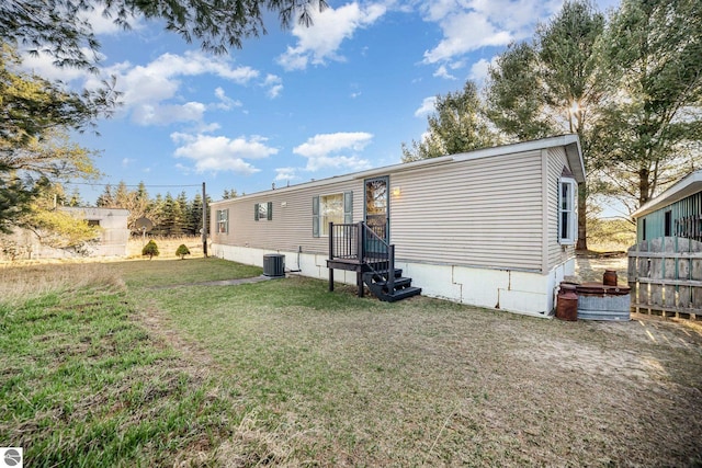 back of property featuring a yard and central air condition unit