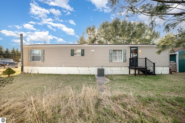 manufactured / mobile home featuring cooling unit and a front lawn